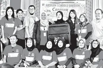  ??  ?? SMART public affairs senior manager Stephanie Orlino (standing third from right) turns over a School-in-a-Bag to Basilan teachers.