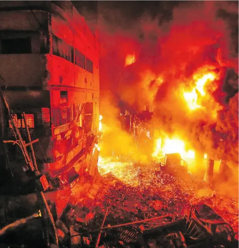  ?? ZABED HASNAIN CHOWDHURY / THE ASSOCIATED PRESS ?? Flames rise from a fire in a densely packed shopping area in Dhaka, Bangladesh, on Thursday. At least 67 people died after the fire tore through five buildings in the centuries-old Chawkbazar area of the capital.