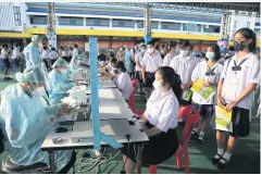  ?? PHOTOS BY VARUTH HIRUNYATHE­B ?? Students queue up for pre-jab registrati­on at Pibool Upphatham School in Bangkok’s Lat Phrao district.