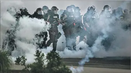  ?? Jason Armond Los Angeles Times ?? MINNEAPOLI­S police advance on protesters who gathered May 30 to decry the killing on May 25 of George Floyd by a police officer.