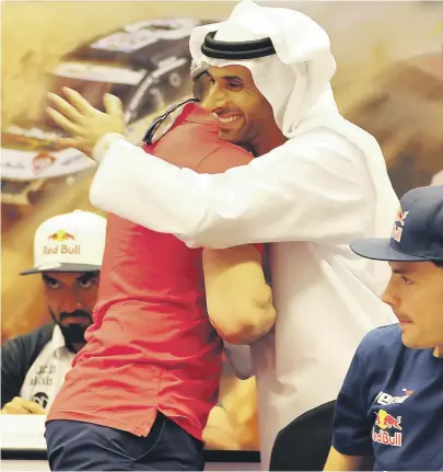  ?? Pawan Singh / The National ?? Sheikh Khalid Al Qassimi greets a fellow driver ahead of the Abu Dhabi Desert Challenge, where he is the defending champion. Sheikh Khalid says a lack of rain will make for softer sand ‘and a need to be careful’