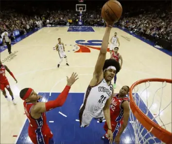  ?? Associated Press ?? A NET GAIN Brooklyn’s Jarrett Allen goes for a dunk between Philadelph­ia’s Tobias Harris, left, and Al Horford Wednesday night in an NBA game in Philadelph­ia. The Nets went on to lose to the 76ers, 117-106. Wednesday’s summaries, Page C-7.