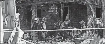  ?? [DAKE KANG/THE ASSOCIATED PRESS] ?? Firefighte­rs probe the remains of a home that burned down Monday morning in Akron. Fire officials said five children and two adults died in the blaze.