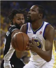  ?? BEN MARGOT — THE ASSOCIATED PRESS ?? The Warriors’ Kevin Durant shoots against the Spurs’ Patty Mills during the first half in Game 1 of a first-round playoff series.