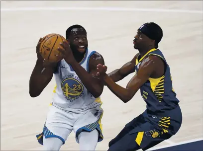  ?? PHOTOS BY DARRON CUMMINGS — THE ASSOCIATED PRESS ?? The Golden State Warriors’ Draymond Green (23) goes to the basket against the Indiana Pacers’ Justin Holiday during the second half Wednesday in Indianapol­is.