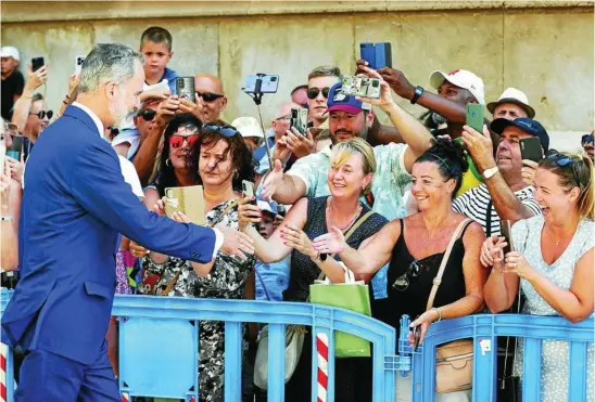  ?? EFE ?? El Rey saluda a los ciudadanos que esperaban en La Almudaina