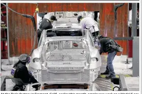  ?? JEFF CHIU / ASSOCIATED PRESS ?? At the Tesla factory in Fremont, Calif., earlier this month, employees work on a Model S car. The U.S. economy likely shrank in the fifirst quarter, analysts say.