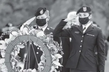  ?? GEOFF CRIMMINS The Moscow-Pullman Daily News via AP ?? Army ROTC cadets Eric Peterson and Anna Drapeau salute after placing a memorial wreath on a stand during a University of Idaho Veterans Day ceremony on Wednesday in Moscow, Idaho.