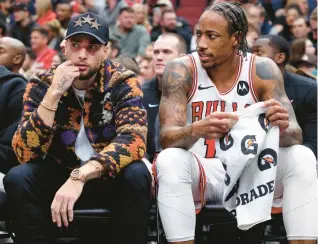  ?? CHRIS SWEDA/CHICAGO TRIBUNE ?? Injured Bulls guard Zach LaVine sits beside forward DeMar DeRozan in the second half against the Nuggets at the United Center on Dec. 12.