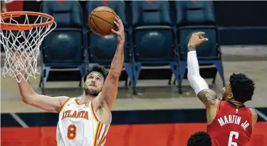  ?? Michael Wyke / AP ?? El delantero italiano de los Hawks Danilo Gallinari (izq.) atrapa un rebote frente a Kenyon Martin Jr. (6) en la victoria del equipo de Atlanta el martes 16 de marzo de 2021 en el Toyota Center de Houston.