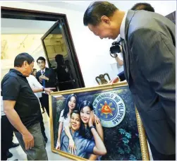  ??  ?? A GIFT FROM CHINA — President Duterte examines a painting of him and his partner Honeylet Avanceña and their daughter Veronica as it is presented to him as a gift on his birthday by Chinese Ambassador to the Philippine­s Zhao Jianhua at the Presidenti­al...