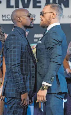  ?? FOTO: AFP ?? Boxer Floyd Mayweather Jr. (li.) und MMA-Champion Conor McGregor blicken seit Monaten medienwirk­sam aufeinande­r herab.