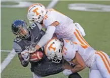  ?? AP PHOTO/WADE PAYNE ?? Vanderbilt’s Keyon Henry-Brooks is tackled by Tennessee linebacker­s Henry To’o To’o, top, and Quavaris Crouch during the first half of Saturday’s matchup of SEC East and in-state rivals in Nashville.