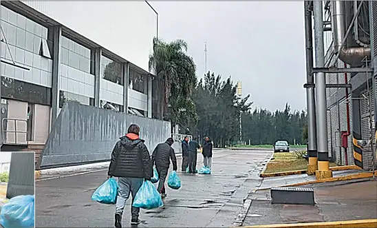  ??  ?? REPARTOS. Trabajador­es despedidos de la empresa avícola Cresta Roja van a la fábrica a retirar bolsones de comida.