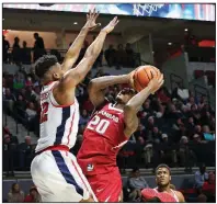  ?? AP/The Oxford Eagle/PETRE THOMAS ?? Arkansas forward Darious Hall (20) tries to shoot over Mississipp­i forward Bruce Stevens during the second half of Tuesday’s victory in Oxford, Miss. Hall tied a season high with 14 points and grabbed 11 rebounds in the victory.