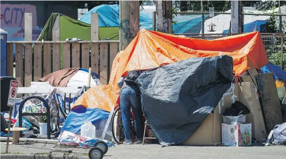  ?? RICHARD LAM/PNG ?? A man leaves the tent city at 950 Main Street on Monday. A judge has ordered the camp dismantled by Wednesday