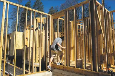  ?? Photos by Santiago Mejia / The Chronicle ?? Jason Buzzard, above, who lost his home in the Camp Fire, checks on the progress of his new residence under constructi­on. Below, Daniel Soto Gomez works to set a foundation for a new home in Paradise.