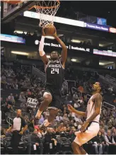  ?? Christian Petersen / Getty Images ?? The Kings’ Buddy Hield goes up for a slam over Trevor Ariza of the Suns. Sacramento led by 27 points after one period.