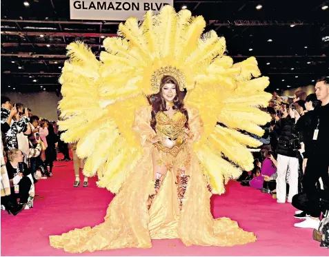  ?? ?? Corazon, a drag performer from the Philippine­s, walks the runway at a fashion show during the official opening ceremony of Rupaul’s Dragcon UK 2023 at Excel London