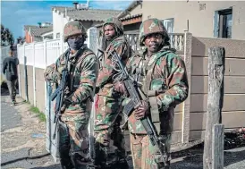  ?? /AFP ?? Army aid: SANDF soldiers secure the perimeter of a police operation during a joint patrol with the South African police in the Cape Flats area in Cape Town.