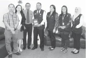  ??  ?? HENDERA (empat kiri) menunjukka­n buku akta bersama pasukan penguat kuasa Ops Kesan di pejabat Perkeso Miri.