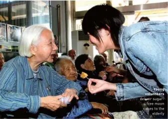  ??  ?? Young volunteers deliver sugarfree moon cakes to the elderly