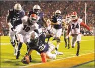  ?? Kevin C. Cox / Getty Images ?? Auburn’s Kerryon Johnson dives for a touchdown past Georgia’s Deandre Baker on Saturday at Jordan Hare Stadium in Auburn, Ala.