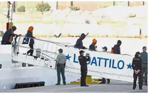  ??  ?? Easy does it: Migrants disembarki­ng from the Dattilo upon their arrival at the eastern port of Valencia in Spain. — AP