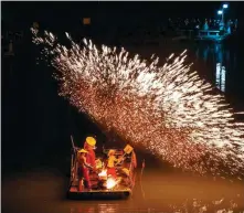  ?? RUAN XUEFENG / FOR CHINA DAILY ?? Tourists in a boat watch an iron flower show across a lake in Hefei, East China’s Anhui province, on Dec 30.