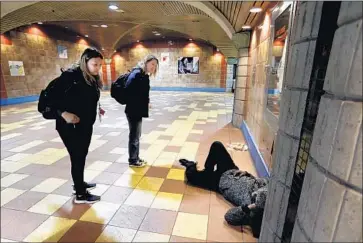  ?? Francine Orr Los Angeles Times ?? JENNY MAURIES, left, and Karen Barnes talk to a man sleeping at a Hollywood Metro station Wednesday. Volunteers with L.A.’s yearly homeless tally counted five people at the Red Line’s two northernmo­st stops.