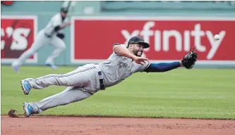  ?? ELISE AMENDOLA THE ASSOCIATED PRESS ?? Blue Jays second baseman Devon Travis dives but can’t come up with a single by Boston’s Mitch Moreland in the first inning at Fenway Park on Monday afternoon. The Red Sox won for the seventh time in nine games.