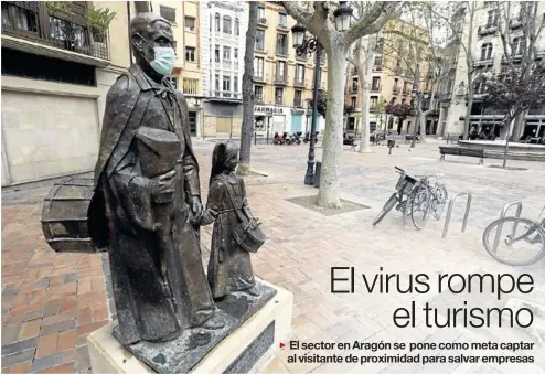  ?? ÁNGEL DE CASTRO ?? El monumento al cofrade de la plaza del Justicia, con una mascarilla que bien podría simbolizar que también ha confinado a la Semana Santa.