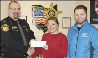  ?? ?? Auglaize County Sheriff Mike Vorhees accepts a check ftom Krista Opperman
and Ryan Douglas. The $1,000 donation will benefit the Shop With The Blue event where law enforcemen­t officers shop at the holidays with local children.
