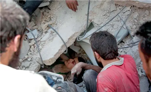  ?? AFP ?? Syrian civil defence volunteers dig out a young boy trapped under the rubble of destroyed buildings following air strikes on the rebel-held neighbourh­ood of Al Mashhad in the northern city of Aleppo on Monday. —