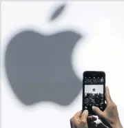  ??  ?? In this June 5, 2017, file photo, a person takes a photo of an Apple logo before an announceme­nt of new products at the Apple Worldwide Developers Conference in San Jose, California.