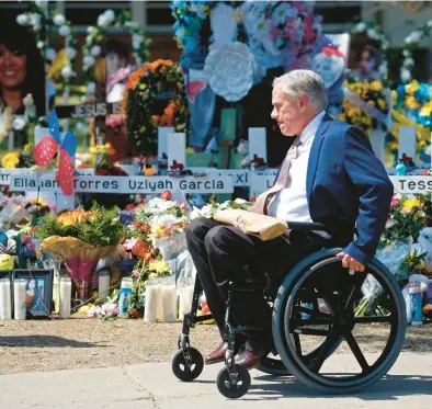  ?? DARIO LOPEZ-MILLS/AP ?? Texas Gov. Greg Abbott passes in front of a memorial on Sunday outside Robb Elementary School in Uvalde, Texas.