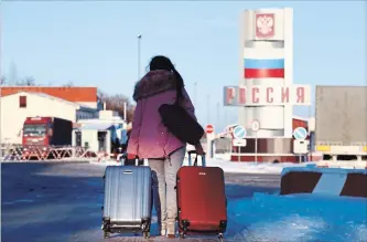  ?? PAVLO PAKHOMENKO
THE ASSOCIATED PRESS ?? A woman prepares to cross the border with Russia in Hoptivka, Ukraine, Friday. Ukrainian officials announced Friday all Russian men 16 to 60 will be barred from entering Ukraine during the 30-day-long martial law.