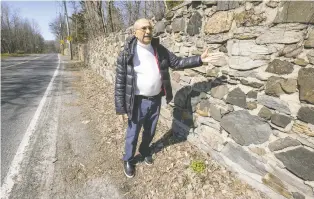  ?? JOHN MAHONEY ?? Bachir Azzi shows the stone wall on the north side of Gouin Blvd. in the Bois-de-saraguay Nature Park. The wall cannot be moved to expand the roadway to add a second sidewalk.