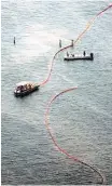  ?? Smiley N. Pool / Houston Chronicle ?? Crews place protective boom near Port Bolivar after an oil spill in March.