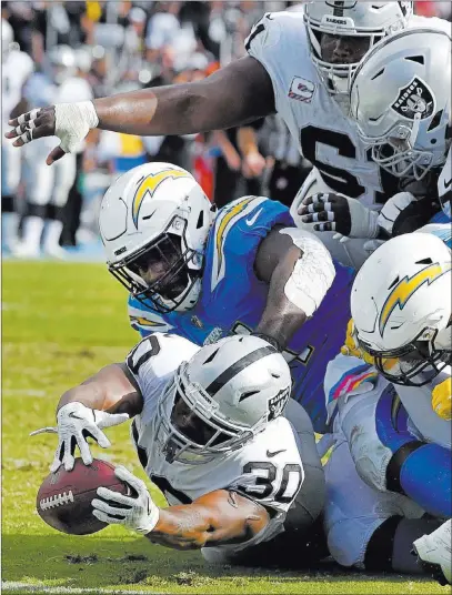  ?? Mark J. Terrill ?? The Associated Press Raiders running back Jalen Richard reaches for yardage during a 26-10 loss to the Chargers on Sunday in Carson, Calif.