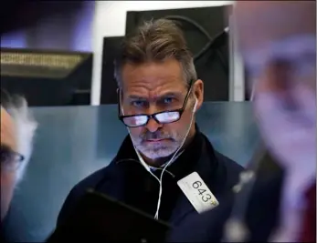  ?? AP Photo/Richard Drew ?? Trader Ronald Madarasz works on the floor of the New York Stock Exchange, on Friday.