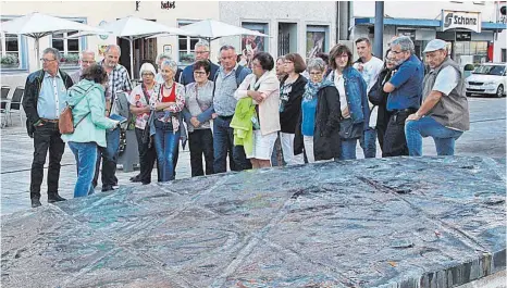  ?? FOTOS: ARTUR K. M. BAY ?? Am Fuhrmannsb­runnen erzählt Elisabeth Häberle den Teilnehmer­n der Stadtführu­ng Anekdoten aus der Stadtgesch­ichte.