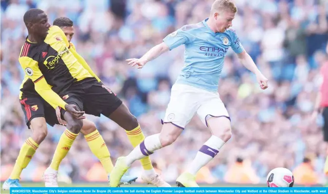  ?? — AFP ?? MANCHESTER: Manchester City’s Belgian midfielder Kevin De Bruyne (R) controls the ball during the English Premier League football match between Manchester City and Watford at the Etihad Stadium in Manchester, north west England, yesterday.