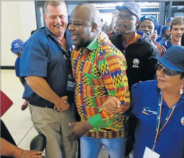  ?? Picture: MICHAEL PINYANA ?? WELL WISHES: New DA Eastern Cape leader Nqaba Bhanga, centre, receives a hero’s welcome and congratula­tions as he arrives at the East London ICC after missing the announceme­nt of his win