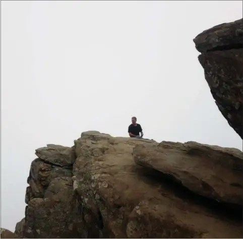  ?? PARIS WOLFE — THE NEWS-HERALD ?? After a strenuous 1.4-mile hike uphill, Gary Mallory of Geneva rests at the edge of Virginia’s Humpback Rocks trying to peer through the fog.