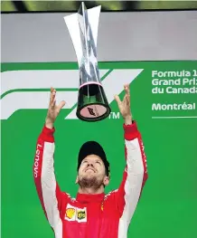  ??  ?? Ferrari driver Sebastian Vettel celebrates winning the Canadian Grand Prix Sunday in Montreal, giving him a one-point lead in the F1 standings.