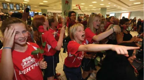  ?? STEVE RUSSELL/TORONTO STAR ?? Members of the Mooredale Lightning U12 soccer team cheer as the Canadian women’s soccer team arrives at Pearson Internatio­nal Airport on Thursday.