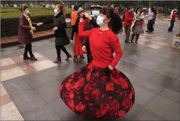  ?? NG HAN GUAN — THE ASSOCIATED PRESS ?? Residents wear masks as they dance at a park in Wuhan in central China’s Hubei Province on Saturday.