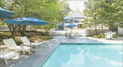  ?? Photos by Coldwell Banker Residentia­l Brokerage ?? Above: Set on 1.5 private wooded acres, 13A Dogwood Lane in Westport features a heated Gunite pool and cabana and an all- weather tennis/ sports court. Below: The newly remodeled kitchen features an island with a breakfast bar, caesarston­e counters and stainless steel appliances.