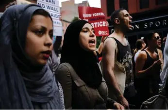  ?? SPENCER PLATT/GETTY IMAGES ?? Recent immigrants joined activists for a protest in Manhattan Thursday, hours before the ban was implemente­d.